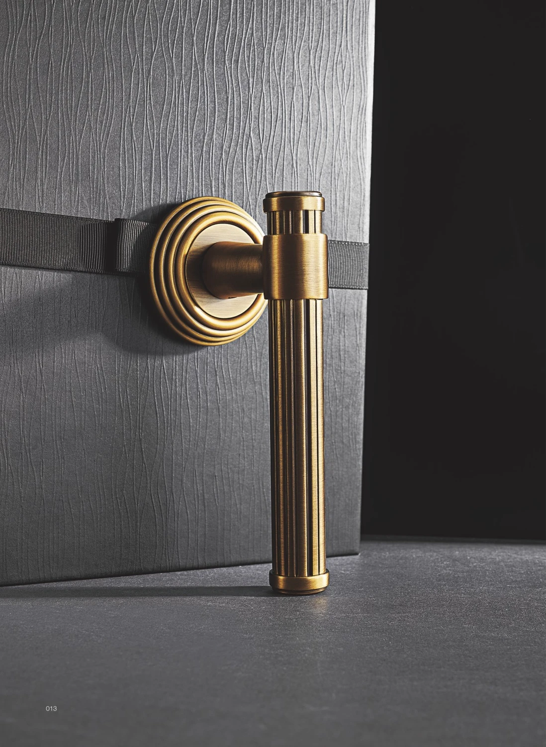 Fluted brass door lever on a dark door